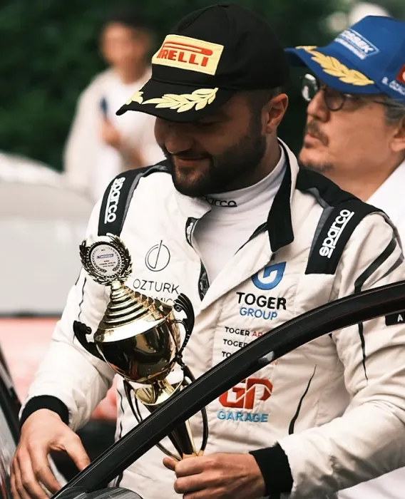 Piloto segurando um troféu de corrida